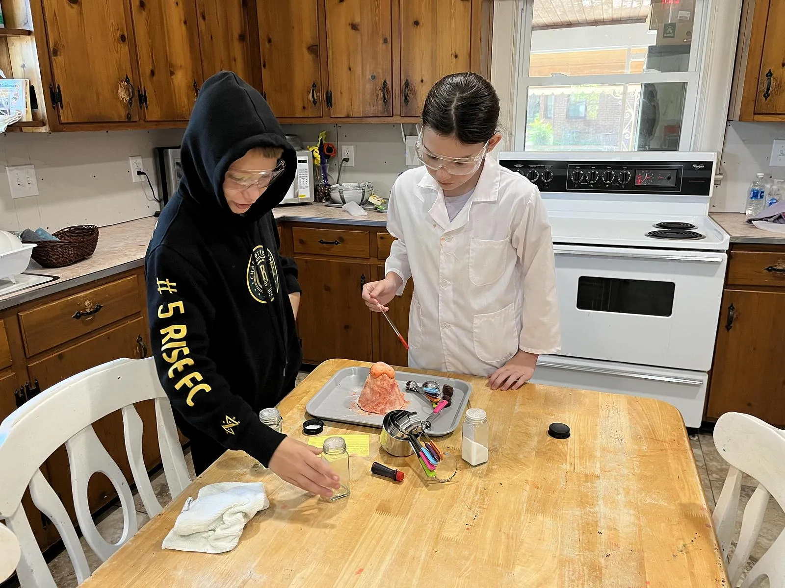 Two children conducting a volcano science experiment 