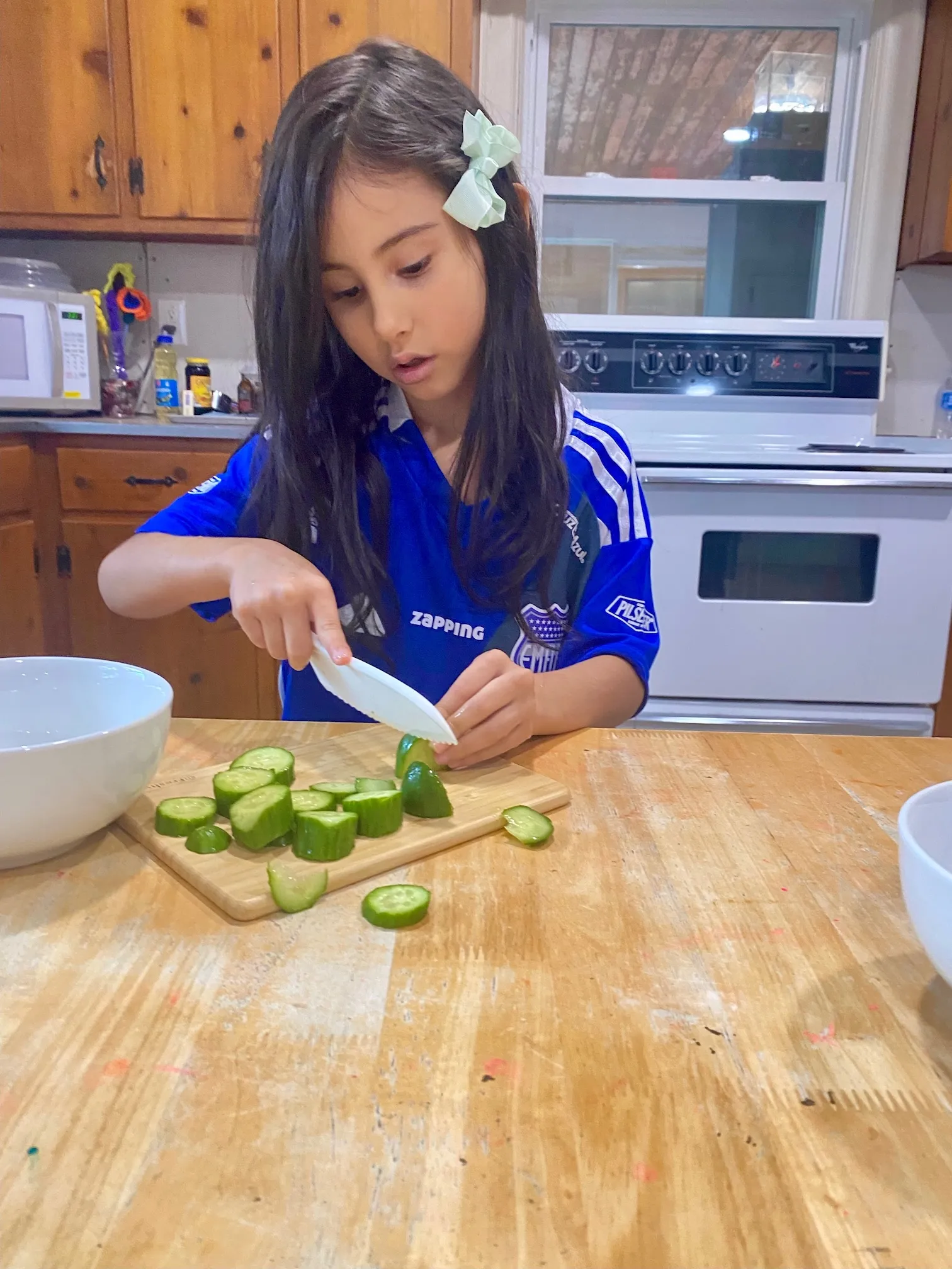 Child cutting cucumbers